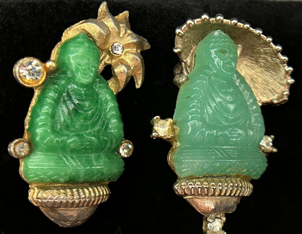 Figure 4 Buddha brooches that resemble those made by Jomaz, but do not feature any trademarks. The one on the left mimics the Jomaz design seen in Figure 2, while the one on the right with the parasol is more unique.