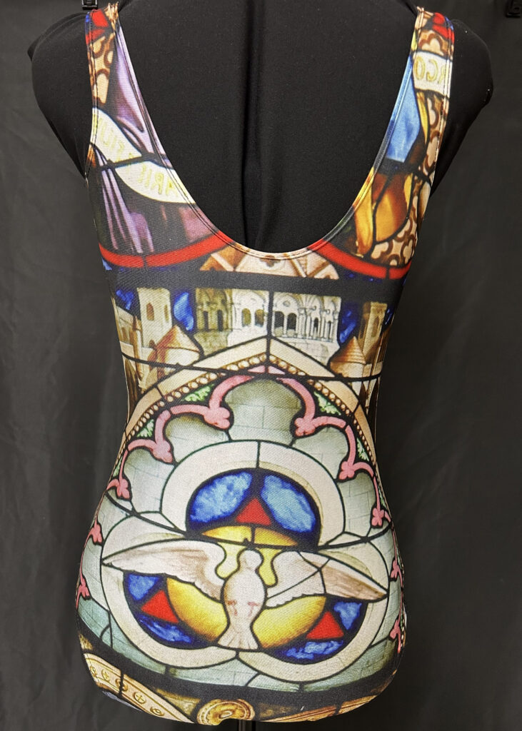 The reverse of the bathing suit featuring a stained-glass dove representing the Holy Spirit.