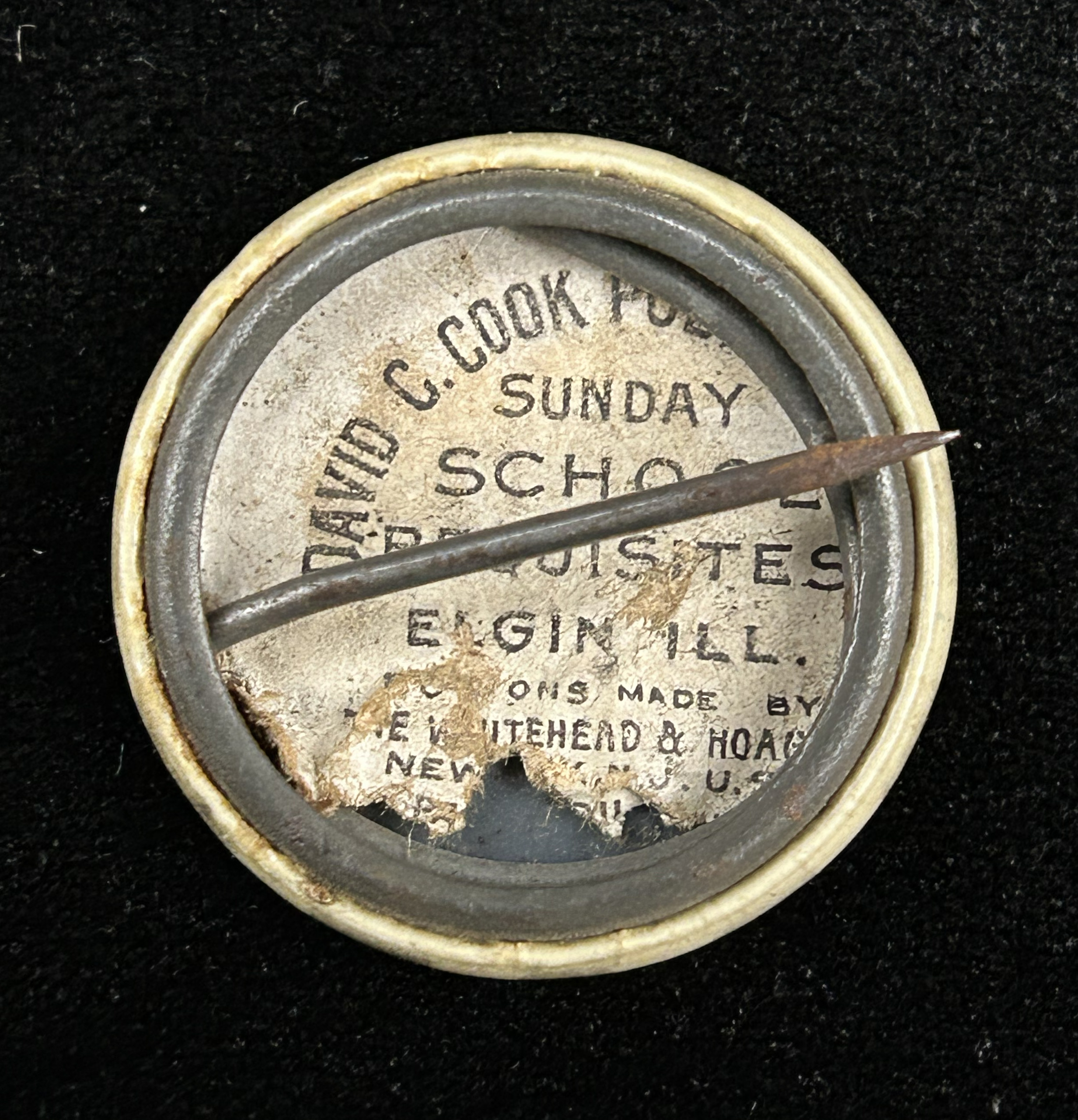 Figure 7: Back of pinback button that shows the partnership between David C. Cook Publishing and Whitehead & Hoag. Photo by author.