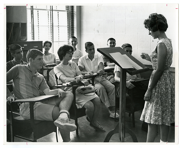 Speech Class at WFU. Female students wear dresses, while male students wear shorts and pants.