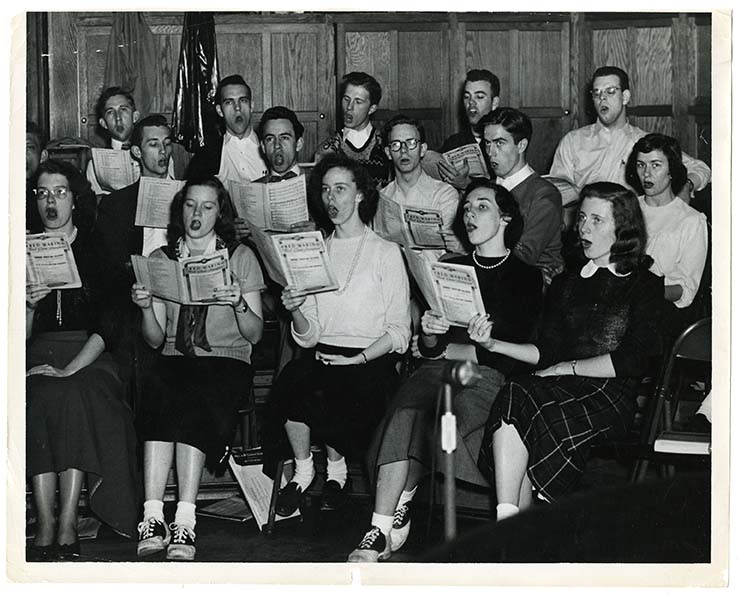 Photograph of student choir rehearsal at WFU. Photograph is undated but female students are wearing skirts, socks, and saddle shoes.