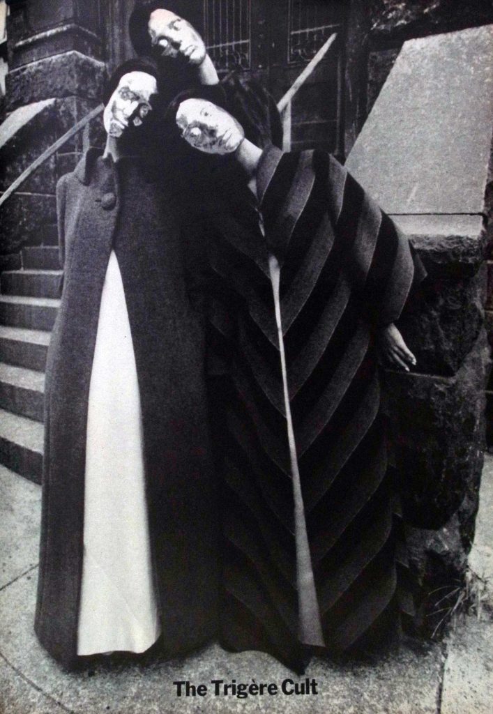 Black and white advertisement of 3 models in coats with metallic masks designed by Pauline Trigère.