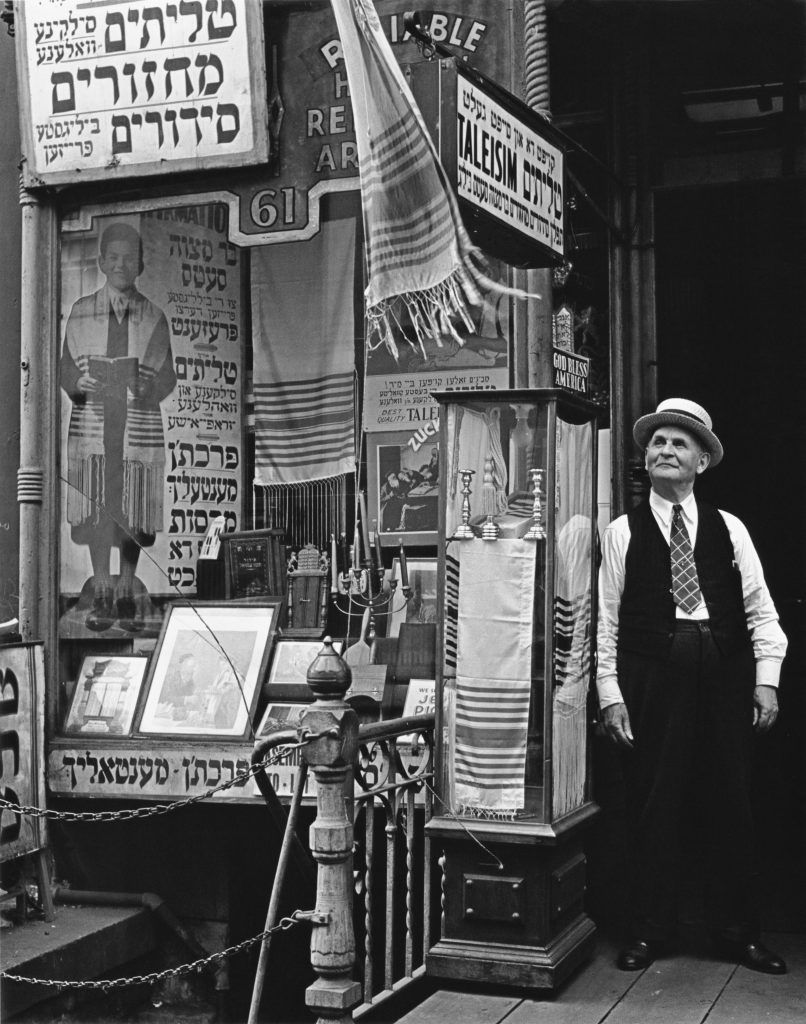 Figure 4: Jewish articles shop on the Lower East Side whose window features a variety of advertisements in Yiddish for a tallit, including one for a “bar mitzvah set,” circa 1940. Photograph by Andreas Feininger © Getty Images.