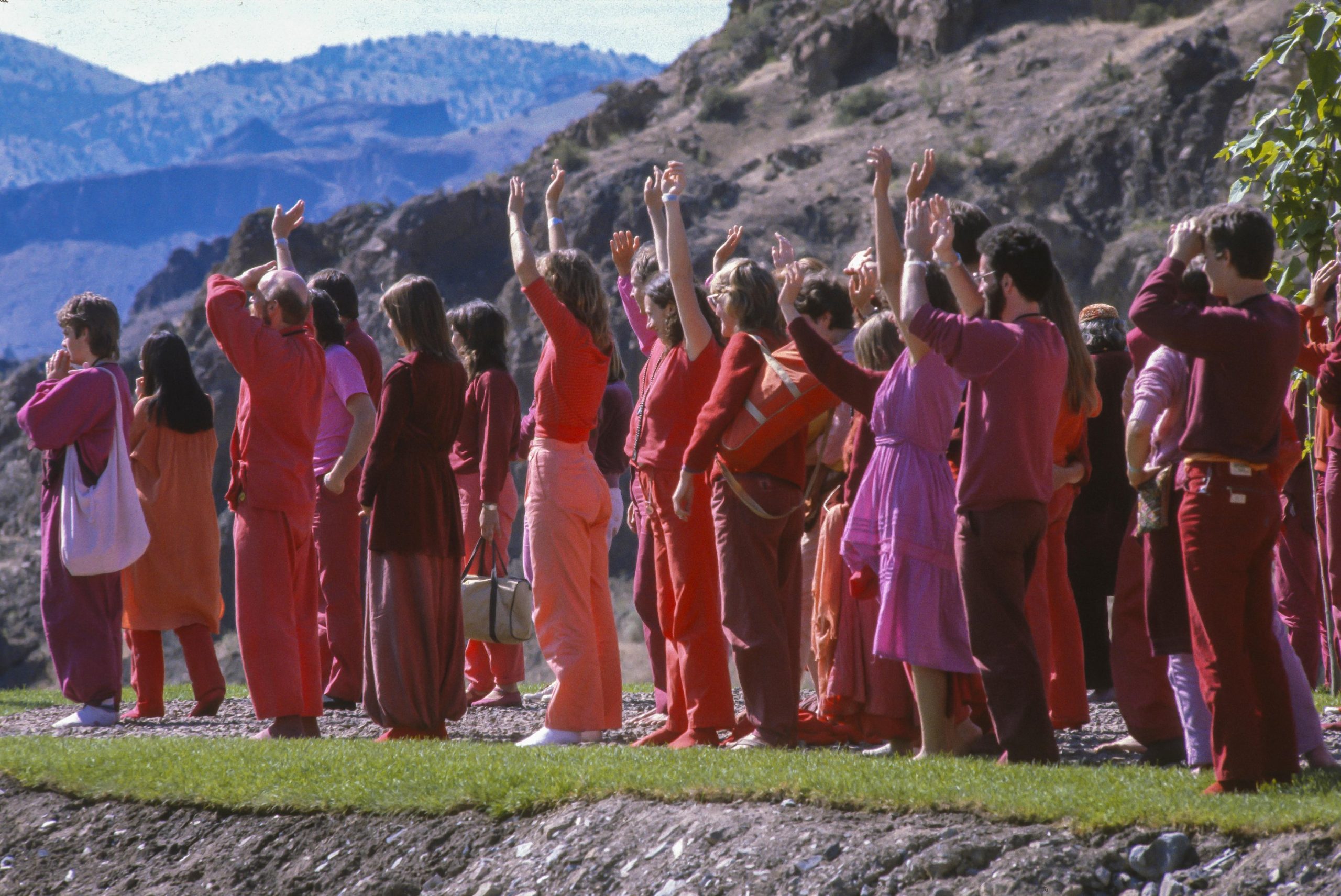 Figure 4: Rajneeshees wearing a variety of clothing in sunrise colors to greet Osho as he drives by in his Rolls-Royce. Photograph © Rob Crandall/Alamy.