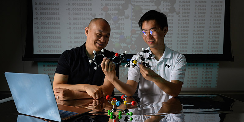 Professor and student with models in classroom