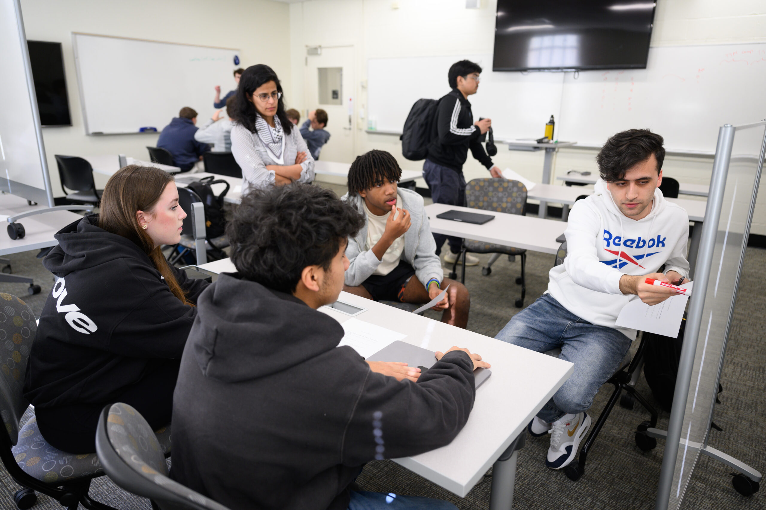 Wake Forest University Computer Science Prof. Sarra Alqahtani teaches her Fundamentals of Computer Science class in Manchester Hall on Friday, February 7, 2025. Prof. Sarra Alqahtani helps Catherine Neely (’28), Elham Fayzi (’28), Mikkel King (’27), and Eddy Picazo (’28) work through an exercise in class.