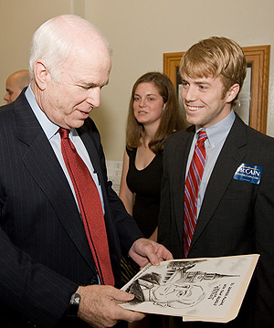 Cartoonist William Warren presents a cartoon he drew of Sen. John McCain when McCain visited campus in May.