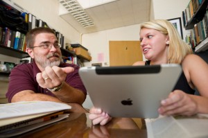 Biology professor Dan Johnson demonstrates the iPad tablet computer to sophomore Rebecca Perry.  