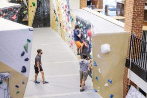 Students wearing masks and using the Wellbeing Center climbing wall