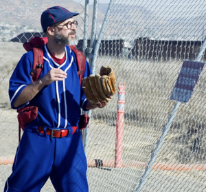 Joel Tauber wearing red, white and blue baseball uniform at US-Mexico border