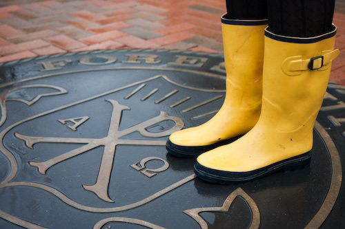 Student with yellow rain boots standing on Wake Forest seal