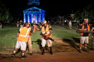 Members of the Wake Forest facilities management team bump fists in front of Wait Chapel