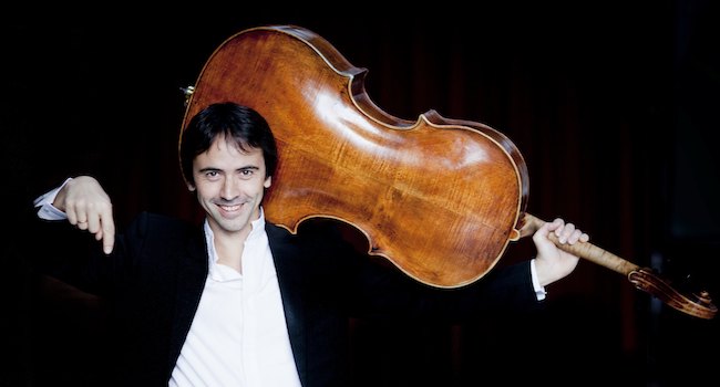 Photo of internationally renowned cellist Jean Guihen Queyras holding his cello on his shoulder and smiling