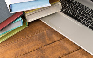 Laptop on a desk with books