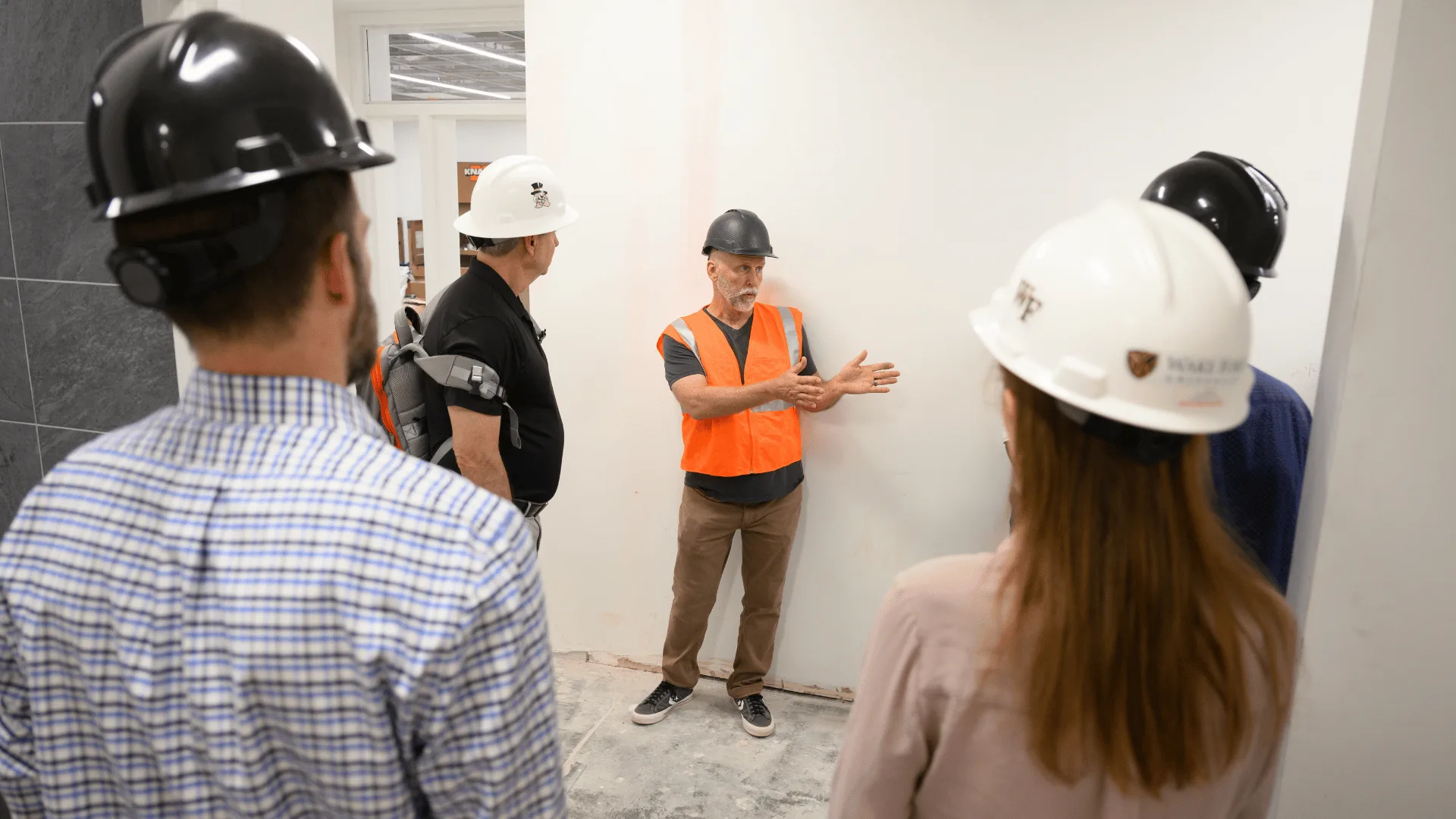 group with hard hats standing in a circle