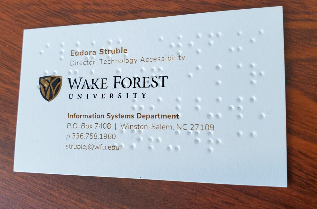 The front of a Brailled business card, showing the printed text over the embossed Braille bumps